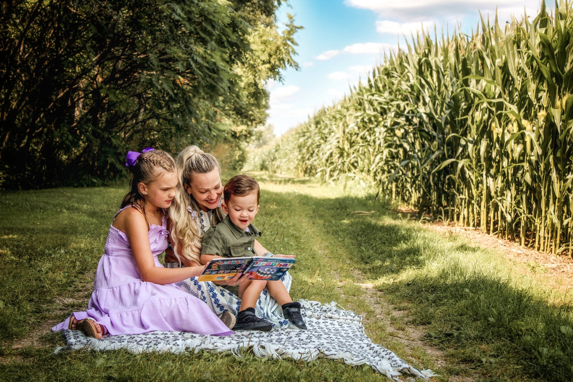 Family reading together by cornfield in Elmira, Ontario - portrait photography by Elmira Photography